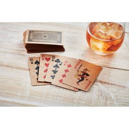 A set of cards featuring the ten of hearts, ten of spades, and ten of diamonds on a wooden surface, alongside a glass of iced drink.