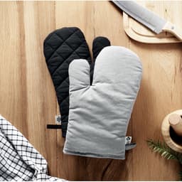 A pair of oven mitts featuring a black quilted design and a grey fabric finish, placed on a wooden surface.