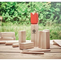 A wooden game set featuring various shaped pieces and a red crown piece, set against a natural outdoor background.