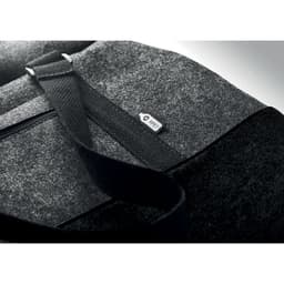 A grey and black felt bag with a strap and a small logo on the side, featuring a zippered compartment.