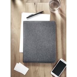 A grey folder rests on a wooden surface near white sheets, a pen, a glass of water, and a smartphone.