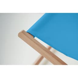 A blue folding chair with a wooden frame, focusing on the fabric and edge detail.