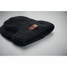 A black knitted beanie with a folded brim and a small leather patch.