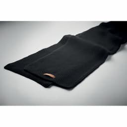 A black scarf with a ribbed texture, featuring a small leather patch.