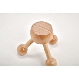 A wooden massage tool with a rounded top and three legs, each ending in a spherical shape.
