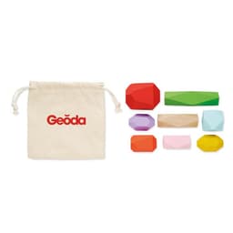 A drawstring bag beside various geometric shapes in green, purple, red, pink, orange, and natural wood. The bag has a logo.