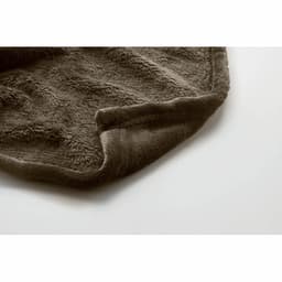 A soft, brown throw blanket with a textured surface, folded at the corner.