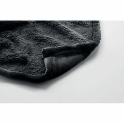 A soft, dark grey blanket with a textured surface is folded at the edge. It features a smooth border.