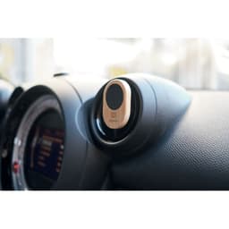 A car air vent mount in a sleek design, featuring a round holder with a black and silver finish, and a logo.