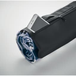 A rolled blanket in a black carry bag with a phone partially visible in the zippered pocket.