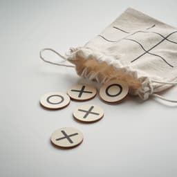 A drawstring pouch with a grid design contains wooden tic-tac-toe tokens featuring 'X' and 'O' symbols.