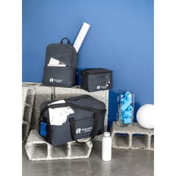 A grey sports bag made from recycled polyester, alongside a backpack, smaller bag, and a drink bottle.