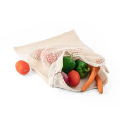 A cream-coloured cotton bag with a mesh front, filled with vibrant vegetables and a small orange.