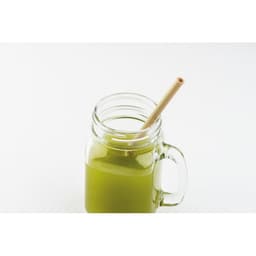 A glass jar filled with green liquid, featuring a natural straw in a light beige colour.
