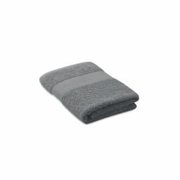 A folded grey towel with a textured and smooth stripe design, featuring a subtle logo.