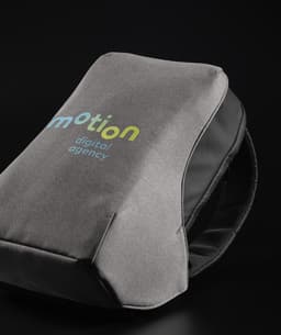 A grey backpack with black accents, featuring a logo on the front, showcasing a modern, sleek design.