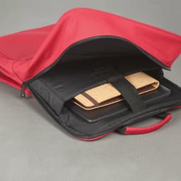 A red backpack with a black interior, featuring a compartment for a 17" laptop secured with a strap.