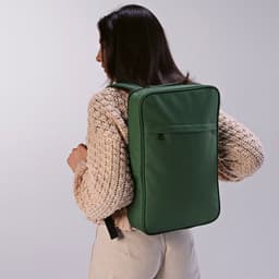 A green backpack with a sleek design, worn on the back, featuring a logo. Suitable for a 17" laptop.