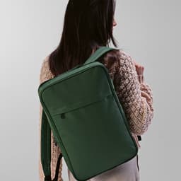 A green backpack with adjustable straps, featuring a front pocket, suitable for carrying a laptop.