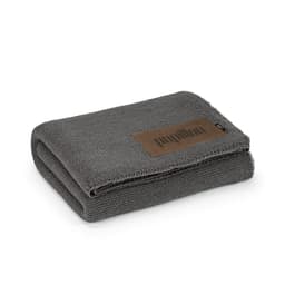A grey blanket folded neatly, featuring a customisable patch and a small logo.