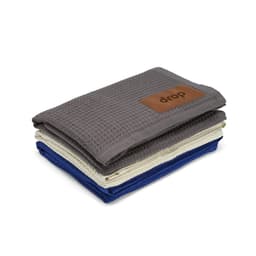 A stack of three Giotto blankets in grey, cream, and blue, featuring a leather patch with a logo.