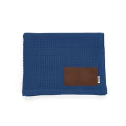 A blue textured blanket with a brown customizable patch. It features a subtle waffle weave design.