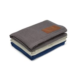 A stack of three Giotto blankets in grey, cream, and navy blue with a customisable patch.