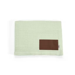 A green waffle-pattern blanket with a brown customisable patch on one side. It has a soft, textured finish.