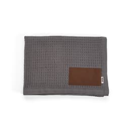A grey Giotto blanket made of cotton, featuring a customisable brown patch. It has a textured, waffle weave design.