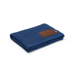 A folded blue blanket with a textured fabric and a customisable brown patch. It features a logo on the patch.