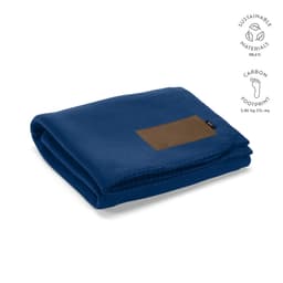 A blue blanket made from sustainable materials, featuring a customisable brown patch and a logo.