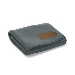 A folded grey blanket made from rPET fabric, featuring a customisable brown patch and a subtle brand logo.
