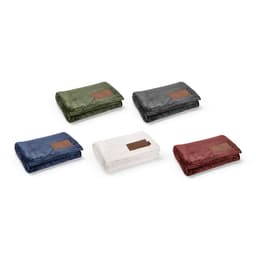 A collection of five folded blankets in green, navy, grey, white, and burgundy, each featuring a customisable patch.