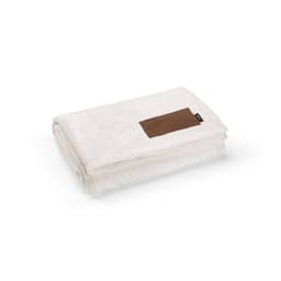 A folded cream blanket with a brown customisable patch. The blanket is made of soft fabric, featuring a logo.
