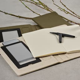 An A4 folder in natural beige with a green cover, featuring a notepad, phone holder, and a pen.