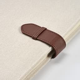 A cream A4 folder with a brown rPU closure, featuring a textured surface and a logo.