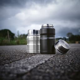 A drink bottle set featuring a silver and a black food flask, each with a metallic finish and a foldable spoon.