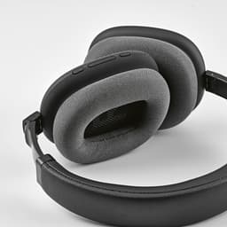 A pair of black headphones with grey ear cushions and a padded headband, featuring buttons on the side.