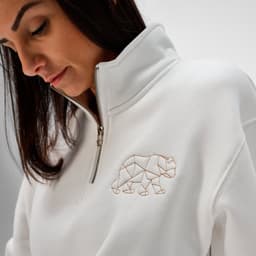 A white quarter-zip sweatshirt made from organic cotton, featuring a bear logo on the chest.