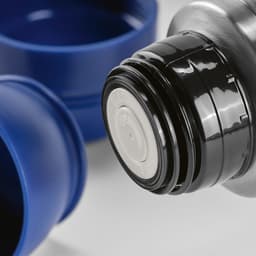A drink bottle with a black lid, accompanied by two blue cups and a carabiner. The product features a logo.