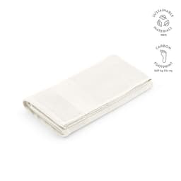 A folded white towel made from 100% cotton, featuring a textured design and a branding logo.