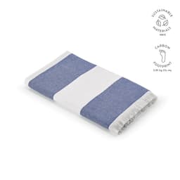 A folded towel featuring blue and white stripes with fringed edges, made from sustainable materials.