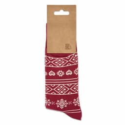 A pair of red patterned socks on a cardboard display, featuring white designs resembling hearts and snowflakes.