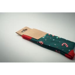 A pair of green socks with red accents, featuring a candy cane pattern, packaged with a brown cardboard tag.
