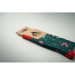 A pair of green socks with candy cane and star patterns, featuring red accents and a branded tag.