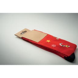 A pair of red socks with festive designs, neatly packaged with a tag attached.