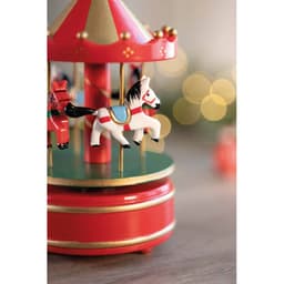 A decorative carousel with red and gold colours, featuring small painted horses and a festive background.
