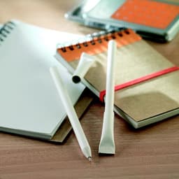 A collection of stationery items including a spiral notebook, a notepad, and two white pens on a wooden surface.