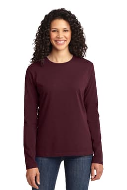 A woman wearing a long sleeve, burgundy core cotton tee. The shirt features a logo and is paired with jeans.