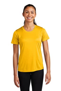 A woman stands smiling in a vibrant yellow Sport-Tek Ladies PosiCharge Competitor Tee, paired with black leggings.
